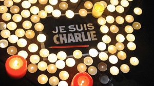 Des bougies sont placées près d'une affiche lisant "Je suis Charlie" et un crayon à La Rochelle le 7 janvier 2015, alors que les gens se sont rassemblés pour rendre hommage aux douze personnes tuées lors d'une attaque par deux hommes armés aux bureaux du journal satyrique français Charlie Hebdo, à Paris - Photo AFP/Xavier Leoty